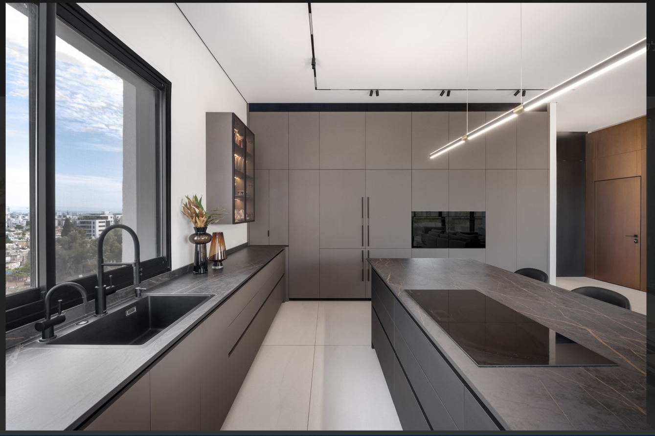 Modern galley kitchen with dark stone countertops, gray cabinetry and a central island