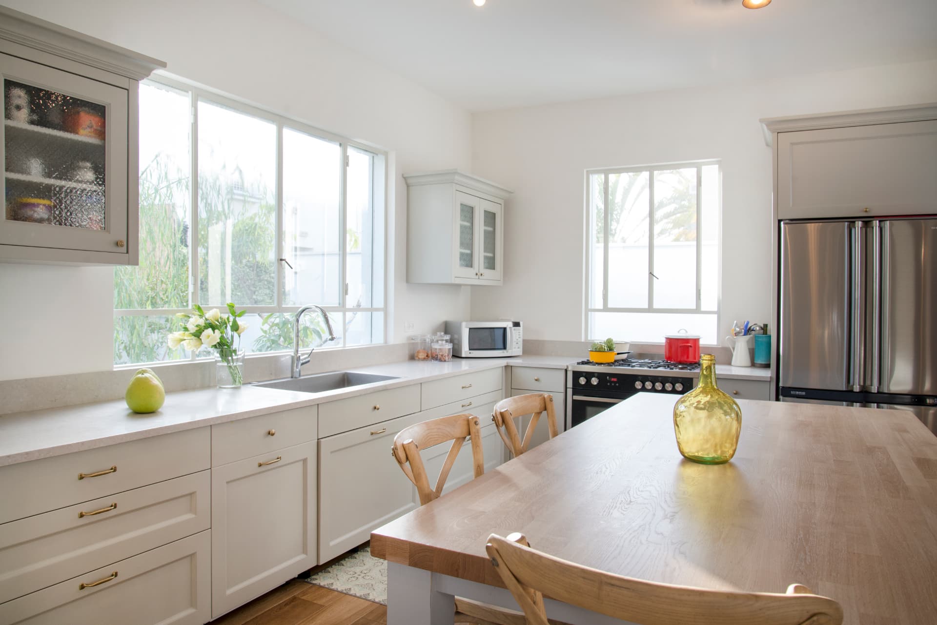 Classic kitchen with shaker cabinetry, brass hardware and an oak table