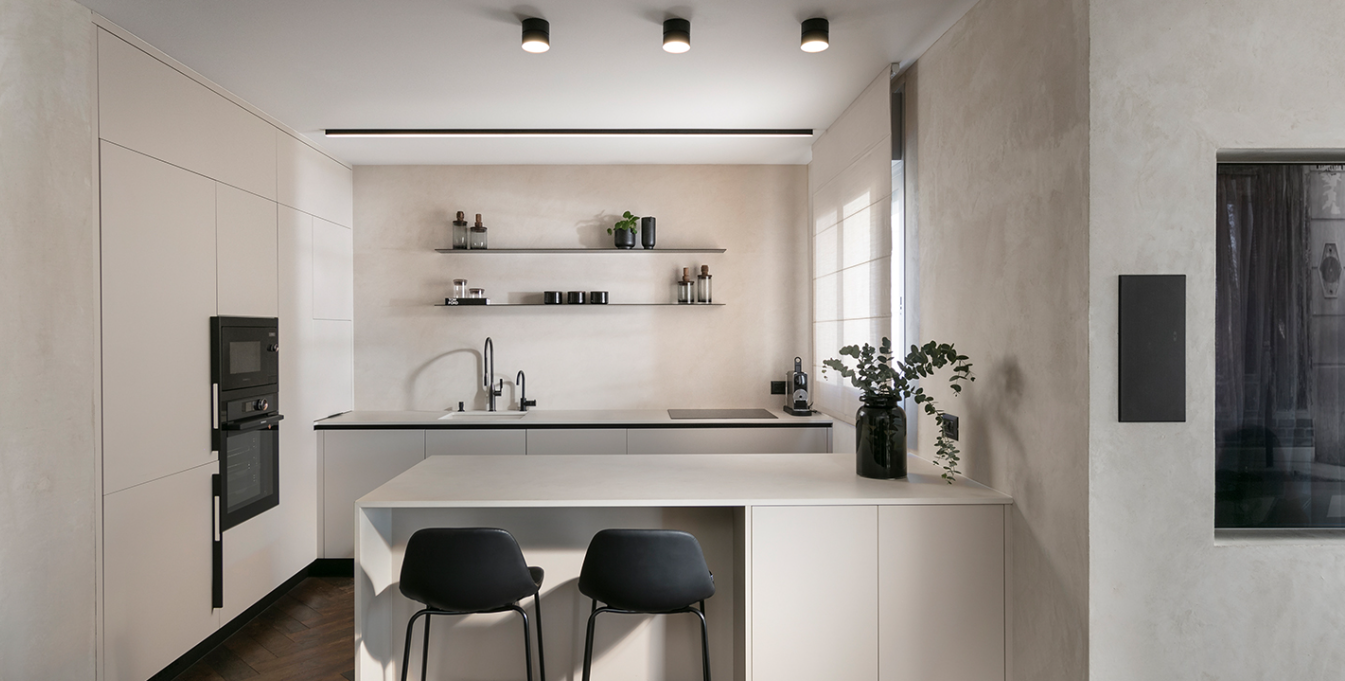 Minimal stone-toned kitchen with handleless cabinetry and floating shelves